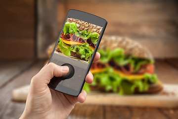 Image showing Hand taking photo of sandwich with smatphone 