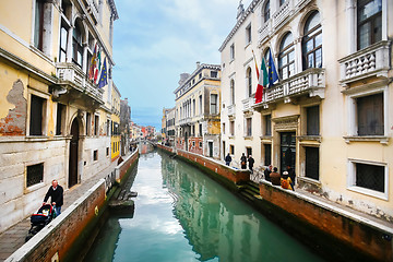 Image showing People walking in sidewalks of water canal