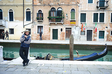 Image showing Gondolier leaning against pillar