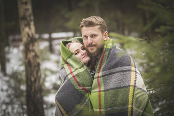 Image showing Young couple winter forest walk in a warm blanket 