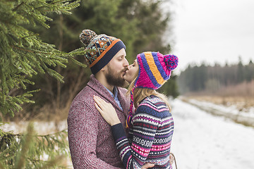 Image showing Young peaople are kissing in winter forest