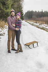 Image showing Young couple having a sled winter forest walk