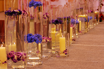 Image showing Row of different vases with flowers and candles