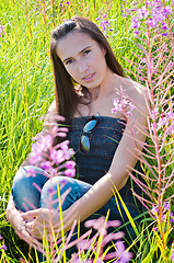 Image showing Beautiful brunette female sitting in field