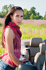 Image showing Beautiful brunette female standing near car