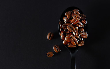 Image showing Roasted coffee beans on black spoon