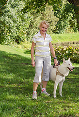 Image showing Woman with a dog on a walk in the park