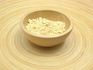 Image showing Wooden bowl with soy meal on bamboo plate