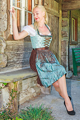 Image showing Woman in Bavarian Dirndl, dreaming and sitting on a bench
