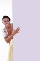 Image showing Beautpeekingiful young woman  out behind wall of office or school 