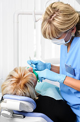 Image showing dentist with patient, cleaning and curing