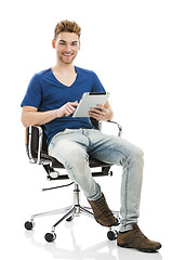 Image showing Young man working with a tablet