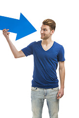 Image showing Young man holding a blue arrow