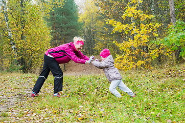 Image showing Woman with girl doing aerobics in the autumn park