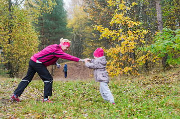 Image showing Woman with girl doing aerobics in the autumn park