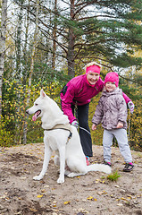 Image showing Granny with her granddaughter and a dog walk in autumn Park  