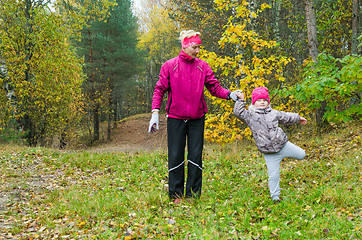 Image showing Woman with girl doing aerobics in the autumn park