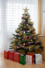 Image showing Decorated christmas tree with yellow and violet balls 