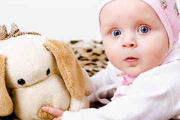 Image showing blue-eyed baby with a soft toy. studio photo