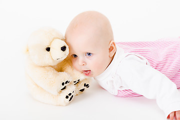 Image showing blue-eyed baby with a soft toy. studio photo