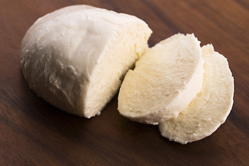 Image showing Sliced mozzarella on wooden board 