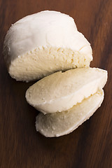 Image showing Sliced mozzarella on wooden board 