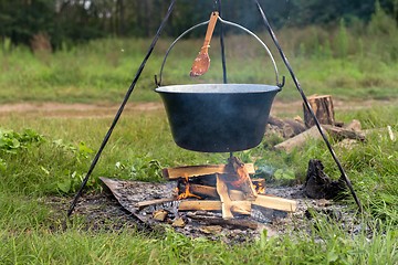 Image showing Camp fire outdoors burning with pot