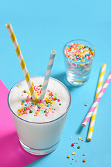 Image showing Glass of milk with striped straws