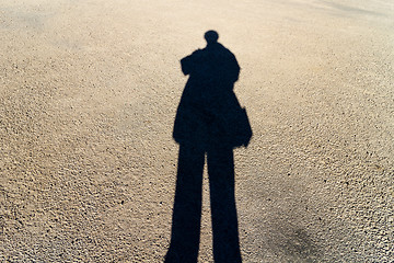 Image showing Elongated Shadow of a Person Standing on the Road