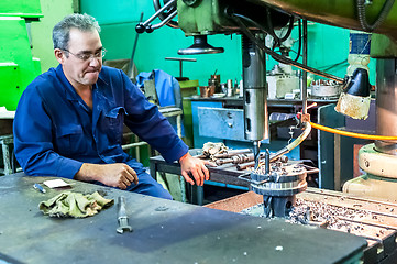 Image showing Senior milling machine operator works at machine