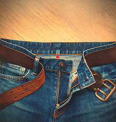 Image showing Aged blue jeans with a leather belt