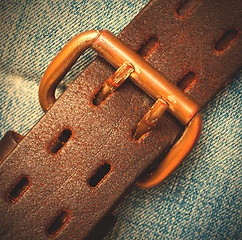 Image showing clasped leather belt on jeans background