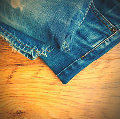 Image showing blue jeans on the wooden shelf