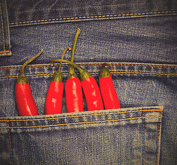 Image showing hot chili peppers in a jeans pocket