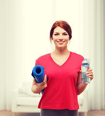 Image showing smiling girl with bottle of water after exercising