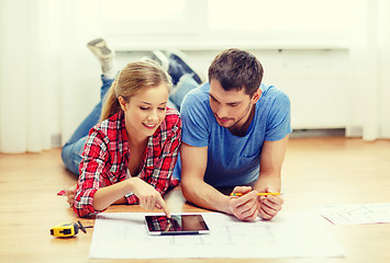 Image showing smiling couple looking at tablet pc at home