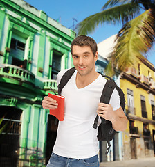 Image showing happy young man with backpack and book travelling