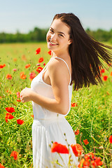 Image showing smiling young woman on poppy field