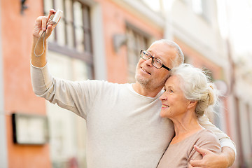 Image showing senior couple photographing on city street