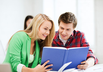 Image showing girl and guy reading book at school