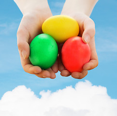 Image showing close up of kid hands holding colored eggs