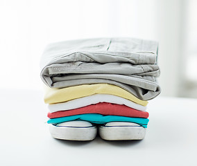 Image showing close up of folded shirts and boots on table