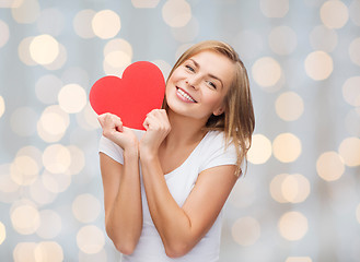 Image showing smiling woman in white t-shirt holding red heart