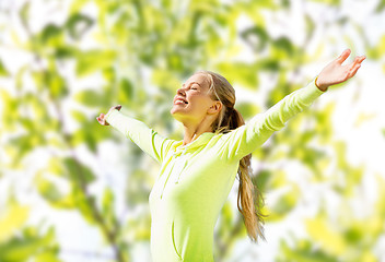 Image showing happy woman in sport clothes raising hands