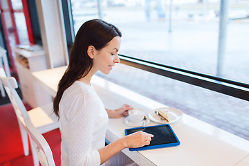 Image showing smiling woman with tablet pc and coffee at cafe