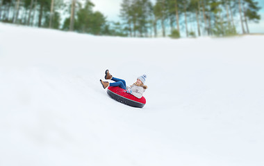 Image showing happy teenage girl sliding down on snow tube