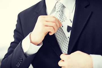 Image showing mans hand hiding ace in the jacket pocket