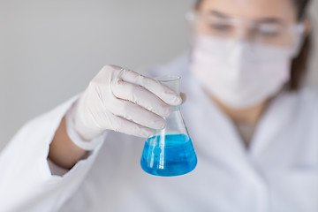 Image showing close up of woman with flask making test in lab