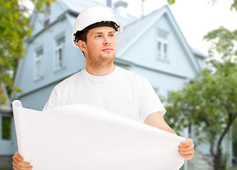 Image showing male builder or architect in helmet with blueprint