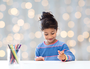 Image showing happy little girl drawing with coloring pencils